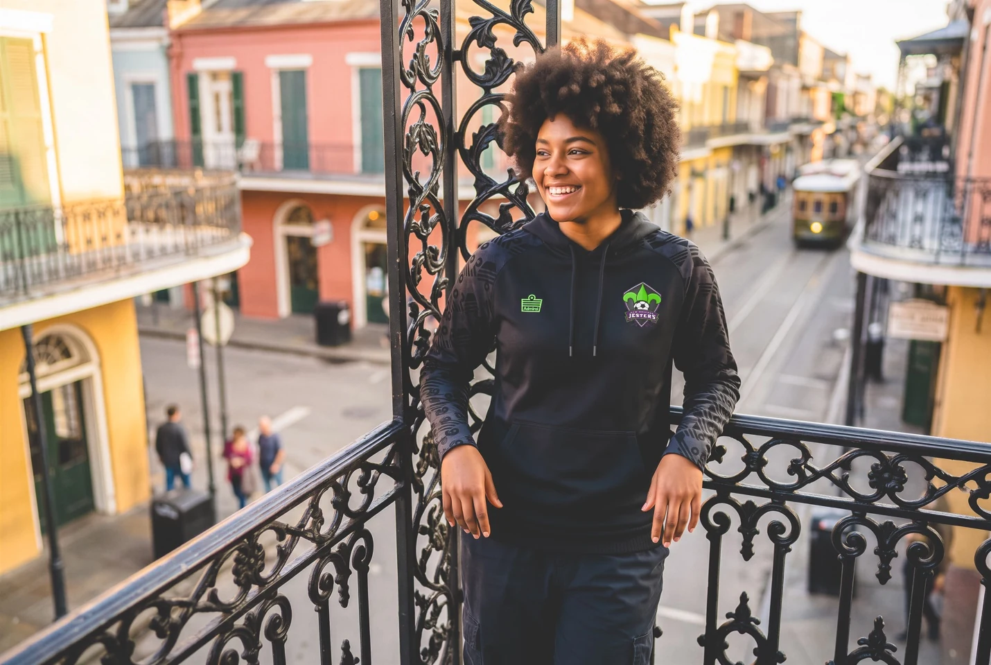 A supporter wearing the black Jesters hoodie on a French Quarter balcony